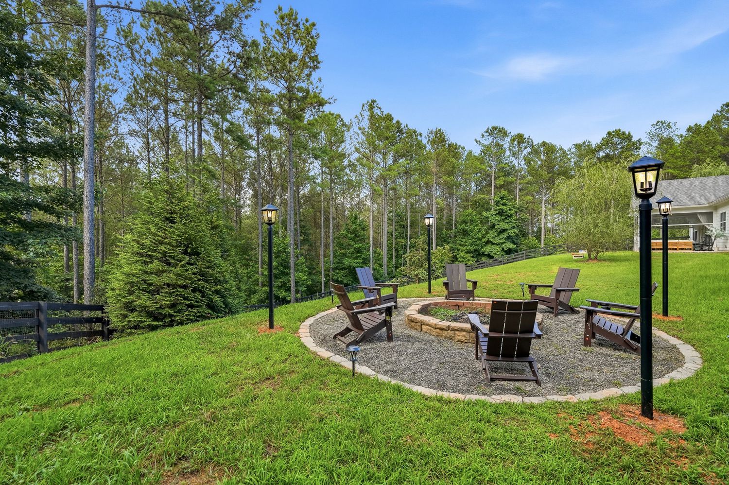 Stone fire pit ringed with Adirondack chairs